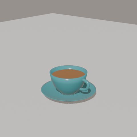 A sea-teal cup of tea on a saucer.