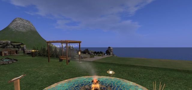 Tidewater at dawn: the mosaic floor round the fire, the pergola and its lights, the sea and a mountain behind.